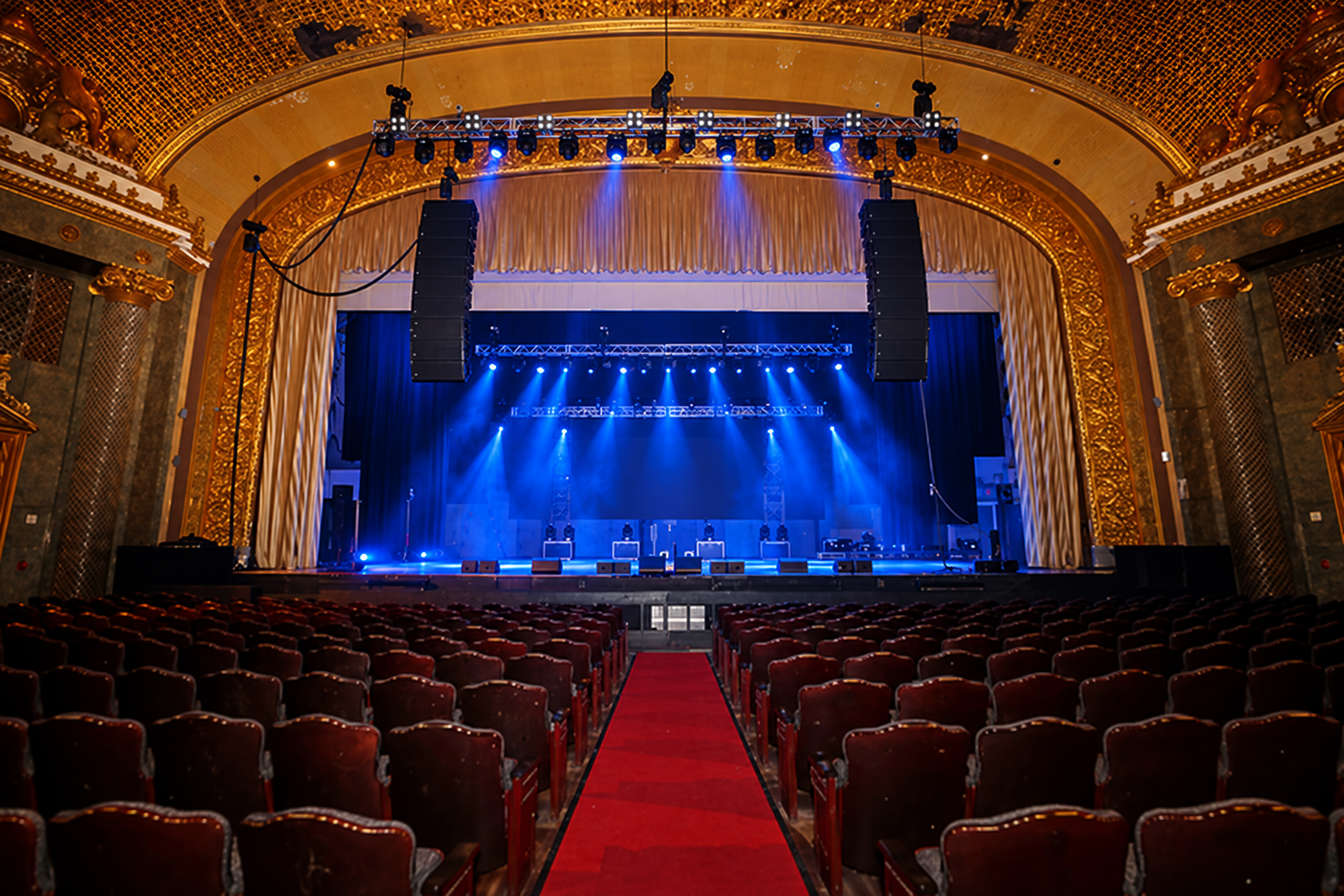 Newark Symphony Hall — wide house view with a deep blue stage wash, flown speaker arrays and lighting truss