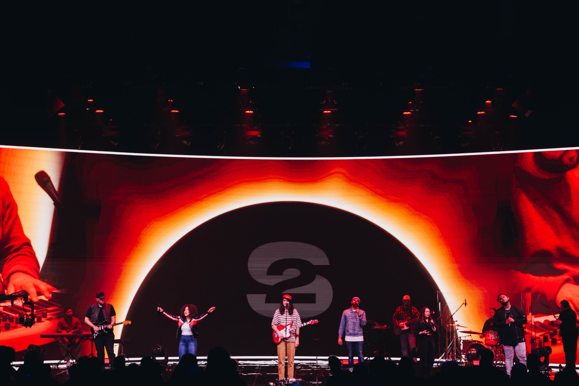 Lit Cornerstone stage with performers beneath white production lighting