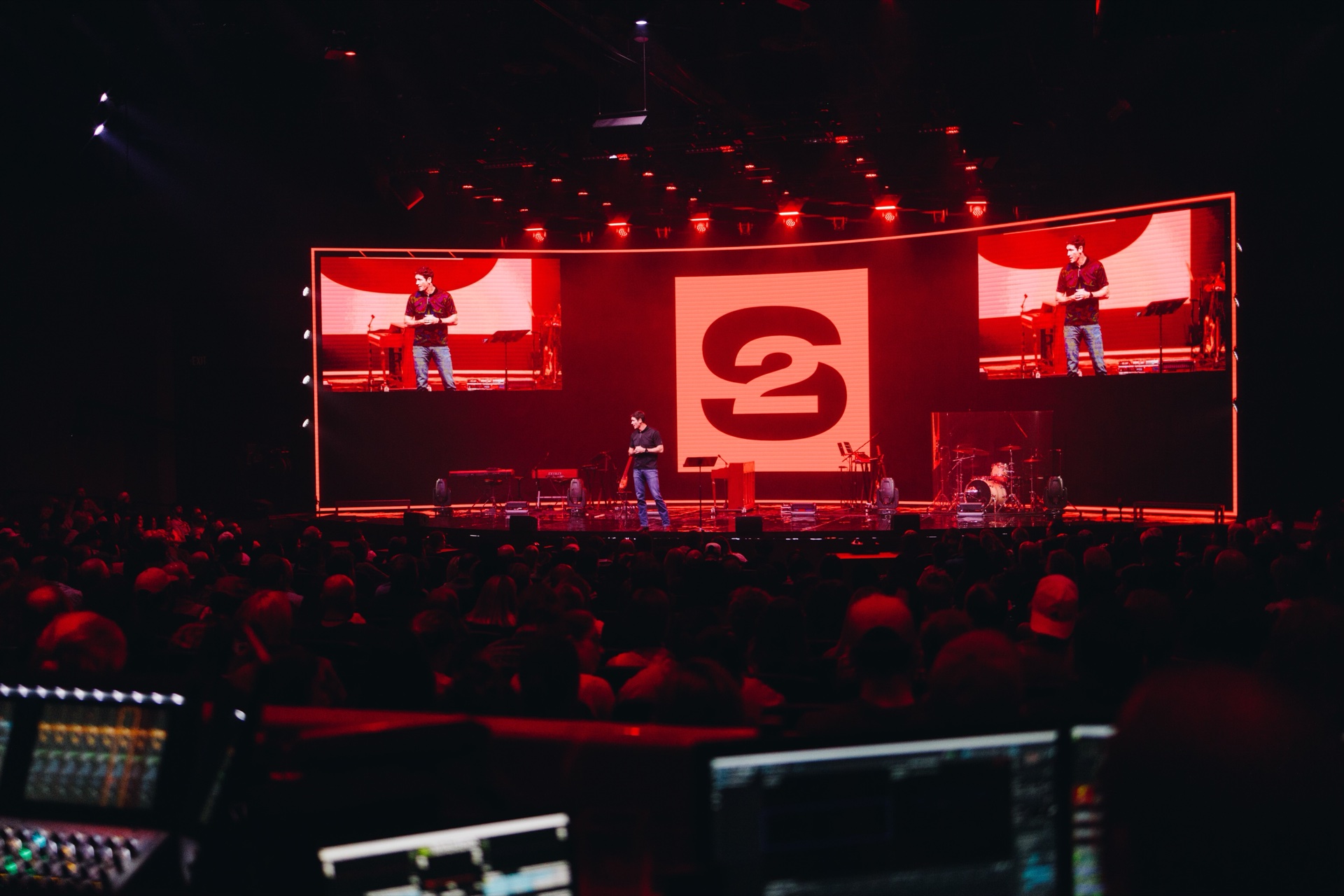 Red and white production lights visible in the dark Cornerstone space